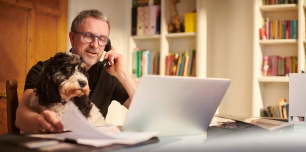 Telepathy mentorship dog in arms of man working
